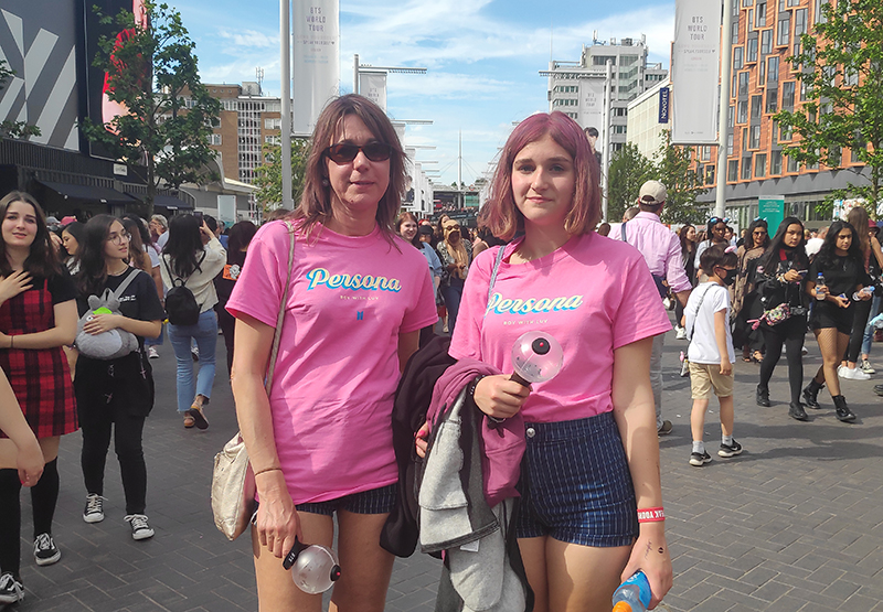 Bev, 51, and Eleanor, 14 (London). This mother and daughter decided on wearing matching striped shorts, T-shirts with the name of BTS' last album and matching fuzzy sandals. This shows a leading trend set by Korean fashion: the matching couple look.